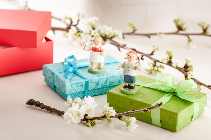 Mädchen und Junge von Wendt und Kühn auf Geschenken stehend